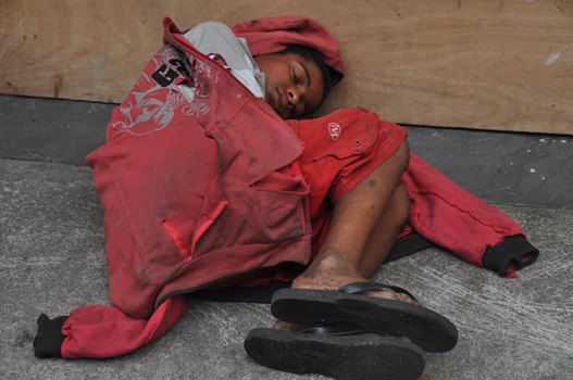 Jovem dependente químico dormindo em uma calçada no Distrito Federal