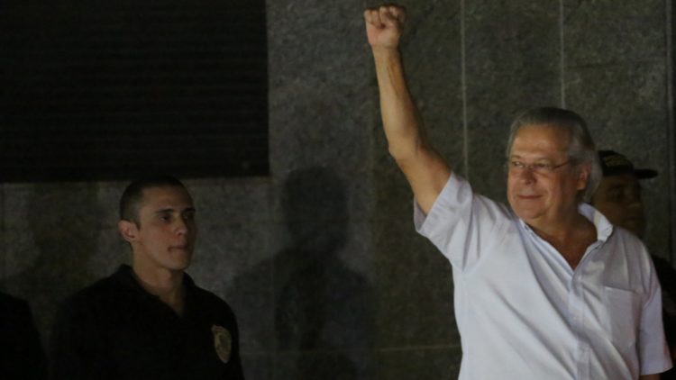 O ex-ministro da casa Civil durante a prisão após a condenação no processo do mensalão: Na época uma figura demonstrando altivez, com o braço erguido e punho cerrado. Agora um homem aparentemente resignado