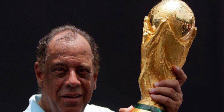Former Brazilian soccer captain Carlos Alberto Torres holds the 2014 FIFA World Cup Brazil trophy during its unveiling ceremony at a Soccerex event at Copacabana beach in Rio de Janeiro, November 21, 2010. Brazil will host the World Cup soccer tournament in 2014. REUTERS/Bruno Domingos (BRAZIL - Tags: SPORT SOCCER)
