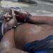 A man's body with his bloodied hands handcuffed lays at a crime scene in Tabarre, a town on the outskirts of Port-au-Prince, Haiti, early Friday, May 1, 2015. Investigators removed three bodies, found handcuffed and blindfolded, from a car that was parked on the side of a street surrounded by open land, and about three blocks from the U.S. embassy. According to police investigators on the scene, the people found dead are Gerda Julien, her brother Robernard Julien and Carl Eduard Guerrier. (AP Photo/Dieu Nalio Chery)