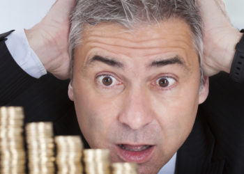 Surprised Businessman With Stack Of Coins