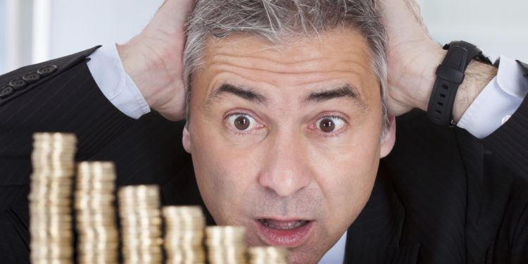 Surprised Businessman With Stack Of Coins