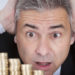 Surprised Businessman With Stack Of Coins