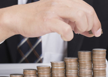 Business women put coin stack money for money growth concept