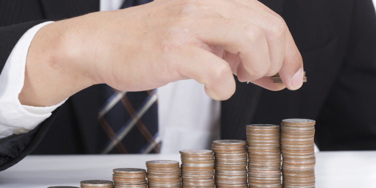 Business women put coin stack money for money growth concept