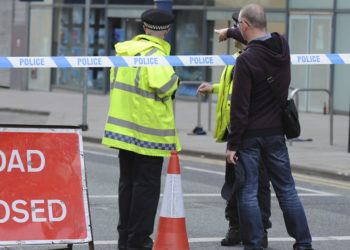 Police block a road near to the Manchester Arena in central Manchester, England Tuesday, May 23, 2017. An explosion struck an Ariana Grande concert attended by thousands of young music fans in northern England late Monday, killing over a dozen people and injuring dozens in what police said Tuesday was being treated as a terrorist attack. (AP Photo/Rui Vieira)