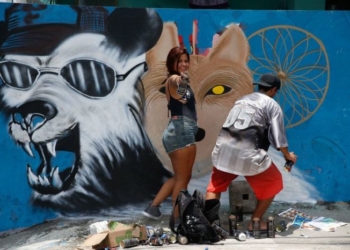 Rio de Janeiro - Grafiteiros, no 12º Meeting of Favela, com o tema Respeite as Origens, pintam paredes na Vila Operária, em Duque de Caxias, que se tornou uma grande galeria a céu aberto (Tânia Rêgo/Agência Brasil)