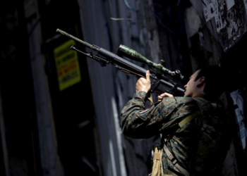 A member of the Police Special Operations Battalion (BOPE) takes a position during an operation against drug dealers in Rocinha slum in Rio de Janeiro, Brazil, January 25, 2018. REUTERS/Ricardo Moraes