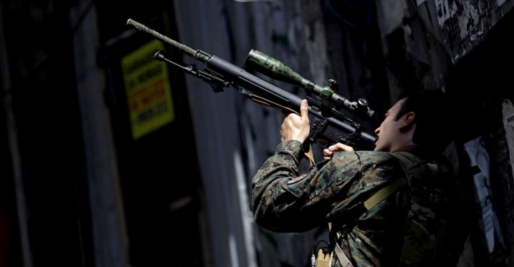 A member of the Police Special Operations Battalion (BOPE) takes a position during an operation against drug dealers in Rocinha slum in Rio de Janeiro, Brazil, January 25, 2018. REUTERS/Ricardo Moraes