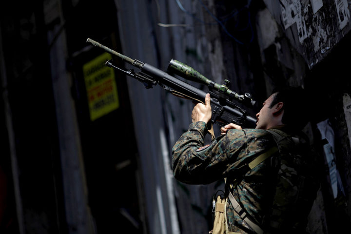 A member of the Police Special Operations Battalion (BOPE) takes a position during an operation against drug dealers in Rocinha slum in Rio de Janeiro, Brazil, January 25, 2018. REUTERS/Ricardo Moraes