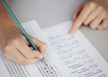 Close up of hands of student doing test.