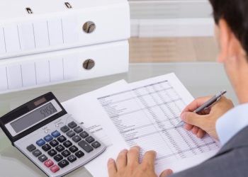 Business man accountant calculating invoices in office