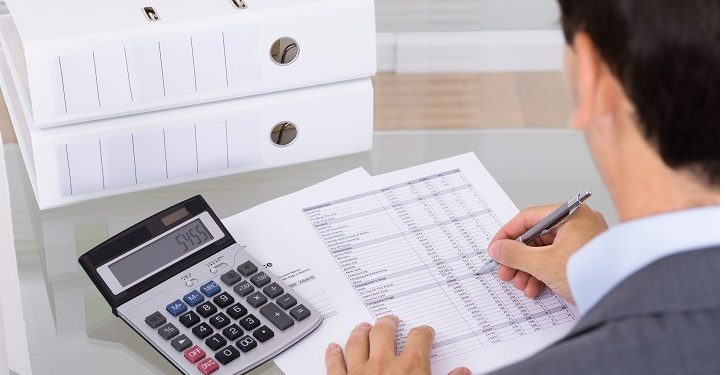 Business man accountant calculating invoices in office