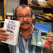 O escritor João Ubaldo Ribeiro com seu livro "O Sorriso do Lagarto", as edições brasileira e em língua inglesa. (Sem local, 26.01.1996. Foto de André Durão/Folhapress)