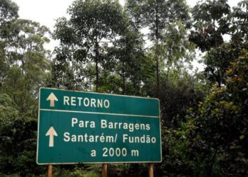 Placa na estrada sinalizando a entrada da barragem de Fundão, cujo rompimento causou a tragédia ambiental.