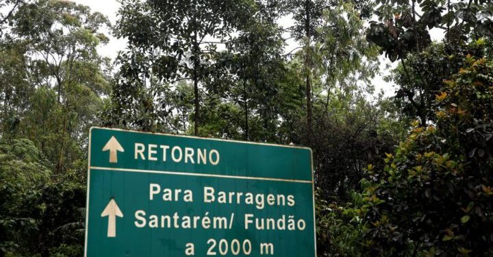 Placa na estrada sinalizando a entrada da barragem de Fundão, cujo rompimento causou a tragédia ambiental.