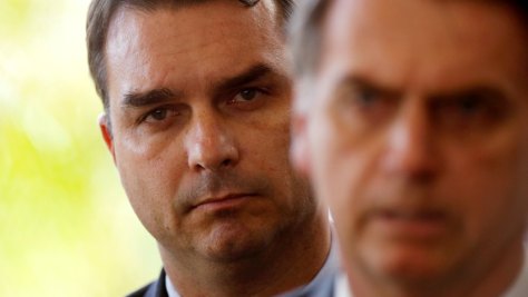 FILE PHOTO: Flavio Bolsonaro, son of Brazil's President Jair Bolsonaro is seen behind him at the transition government building in Brasilia, Brazil November 27, 2018. REUTERS/Adriano Machado/File photo