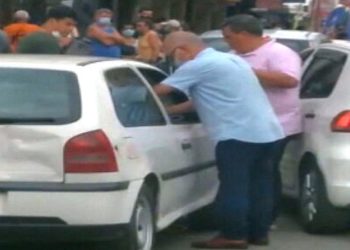 José Carlos de Oliveira é visto aplicando a vacina em uma das vias da cidade, acompanhado por um homem que carrega um isopor com as doses.