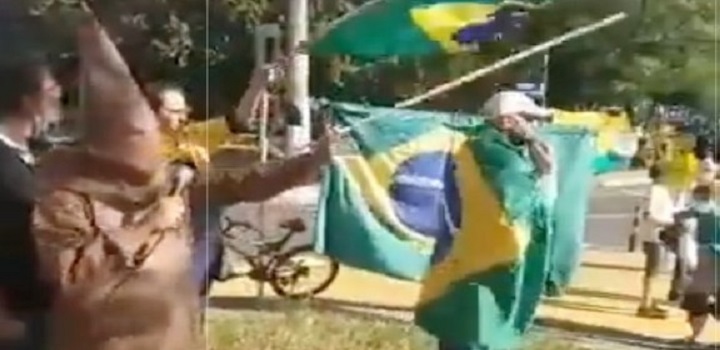 homem homem vestido com trajes semelhantes aos da Ku Klux Klan discursou durante um ato a favor do presidente Jair Bolsonaro