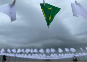 Ato em memória dos quase 600 mil mortos pela Covid no Brasil estende lenços brancos em Copacabana