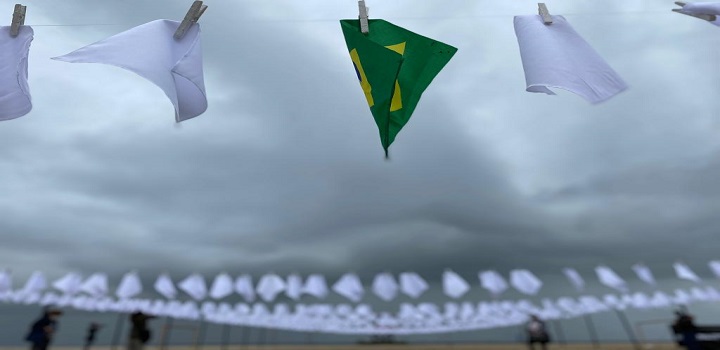 Ato em memória dos quase 600 mil mortos pela Covid no Brasil estende lenços brancos em Copacabana