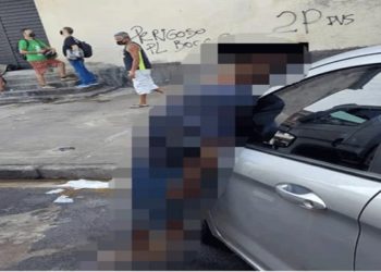 homem morto em pé e encostado em carro