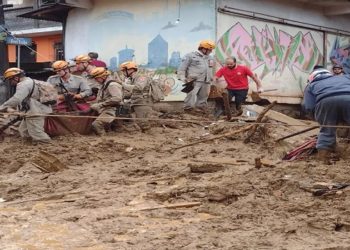 Corpo sendo retirado, na manhã desta quarta (16), da barreira que atingiu o Morro da Oficina, em Petrópolis — Foto: Alexandre Kapiche/g1