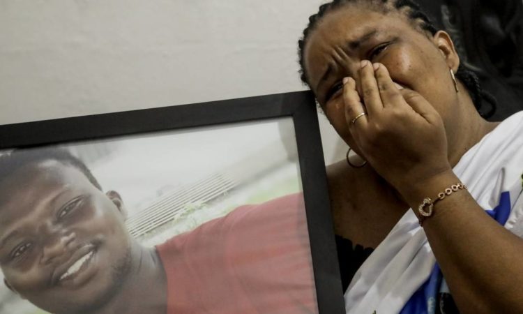 Sofrimento. Lotsove Lolo Lavy Ivone, comerciante congolesa, no Rio desde 2014, abraça o retrato do filho, que foi assassinado na Praia da Barra depois de escapar da guerra em sua terra natal Foto: Gabriel de Paiva / Agência O Globo