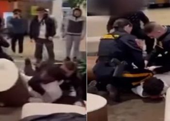 Policial acalma jovem branco enquanto outro algema negro em briga no shopping