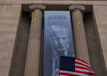 Departamento de Justiça dos EUA exibe cartaz com foto de Donald Trump
