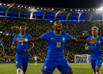 Jogadores do Brasil comemoram em estádio lotado durante jogo decisivo pela fase de grupos da Copa.