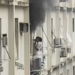 Mulher se abriga na área externa de prédio após incêndio atingir apartamento em Copacabana, na Zona Sul do Rio.
